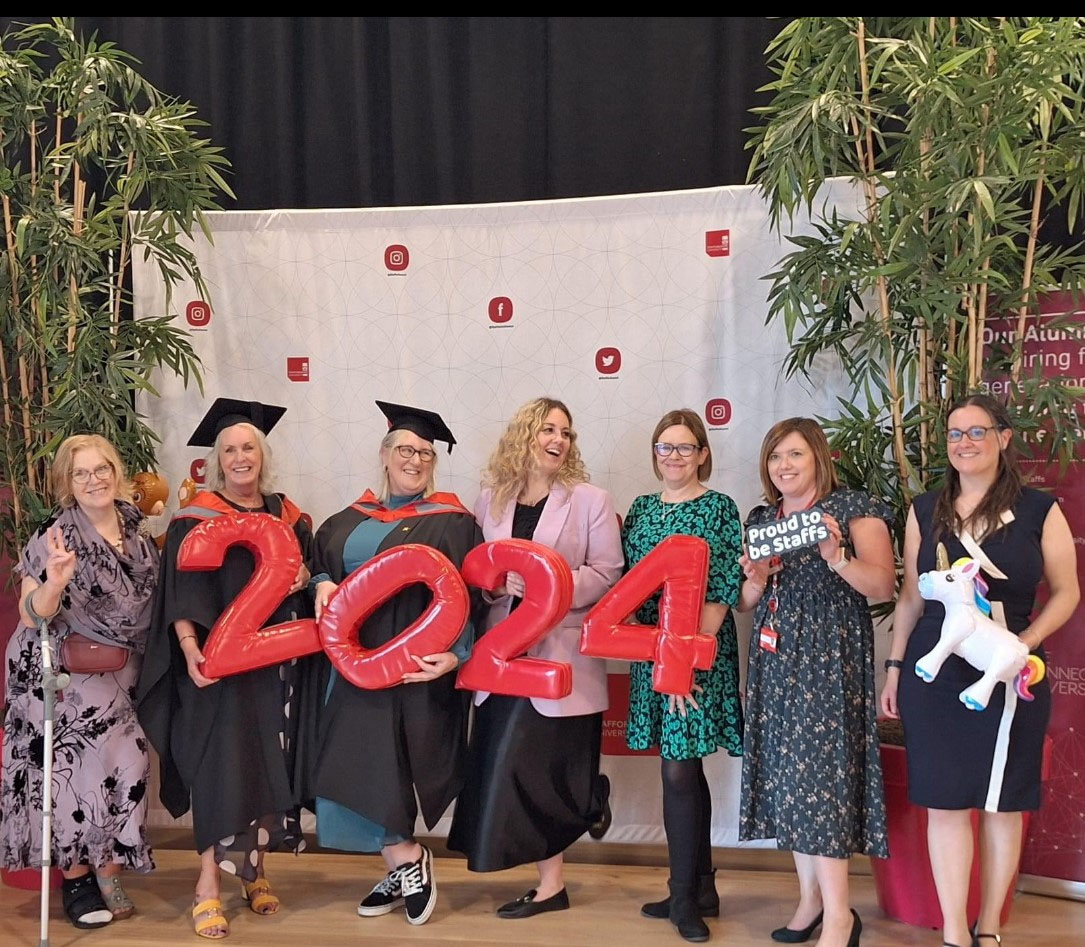 A group of female SUCs dressed formally are celebrating during a photoshoot at a graduation event