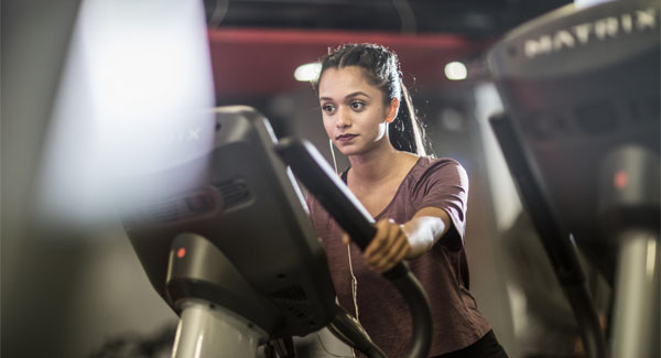 A female with a ponytail is wearing gym clothing and using the cross-trainer at the Stanley Matthews gym