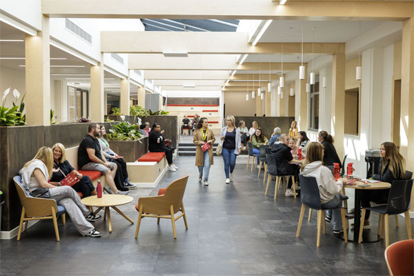 Students and parents are sitting in a modern open bistro space on an open day at Stafford campus