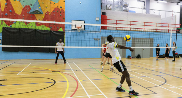 Sports students playing volleyball in the indoor sports hall at University