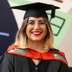 A smiling graduate posing for a photo.