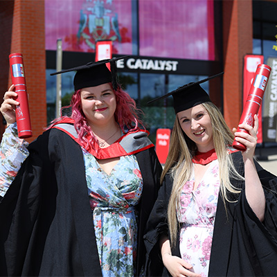 Courtney Lee and Skye Gilbert on their graduation days wearing caps and gowns