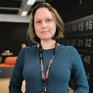 A female graduate in blue sweater posing for a photo.