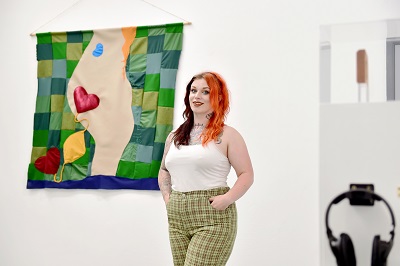 Eve Travis in front of her work