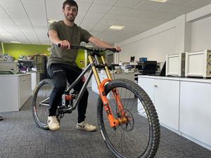 Man sat astride a bicyle in an engineering lab 