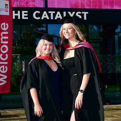 Sian and Emma in their graduation caps and gowns