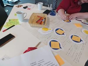 Table with sheets of paper pens and post it notes