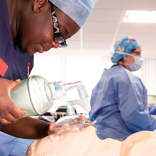 nursing student practices skills on a dummy in the clinical simulation suite