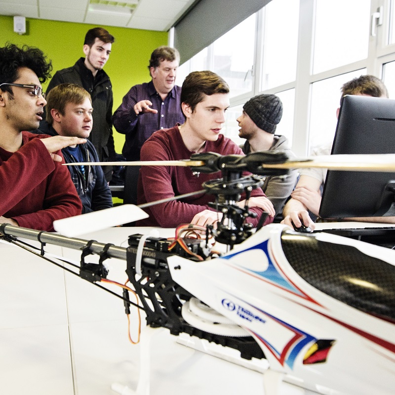 A group of aeronautical students and their lecturer discussing a project