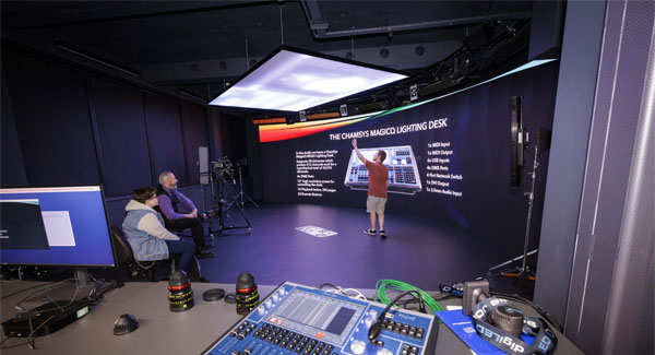 A technical expert is in the media production studio demonstrating the equipment