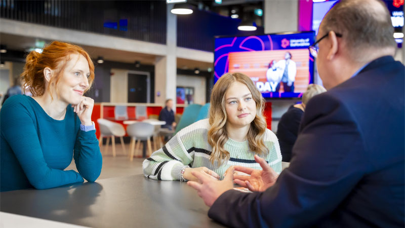 Female visitors are sitting in the Catalyst getting advice from an expert