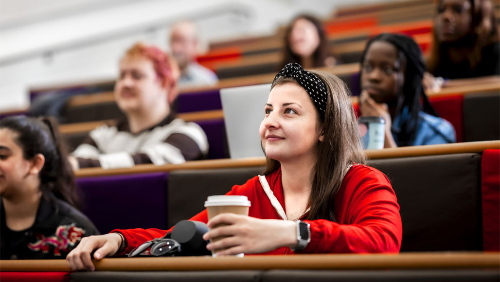 A group of students are sitting in a lecture theatre listening to a talk